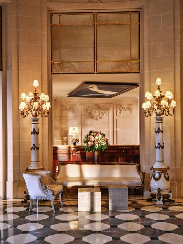 A luxurious room at Le Meurice, Paris, featuring a couch and chandeliers, venue of Pablo Picasso's wedding banquet.