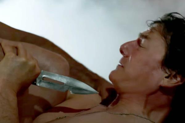 Tom Cruise in a tense scene from the trailer of Mission: Impossible - The Final Reckoning, battling an enemy with a knife at his throat.