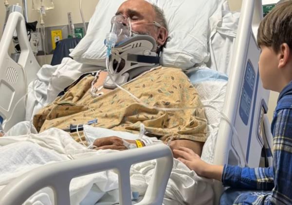 a man in a hospital bed wearing a mask