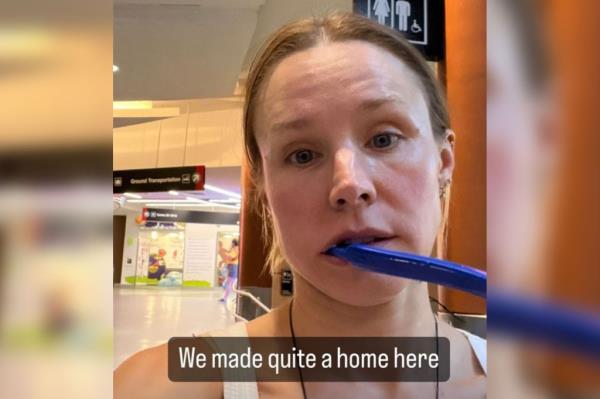 Kristen Bell takes a selfie with a blue toothbrush hanging out of her mouth with the caption 