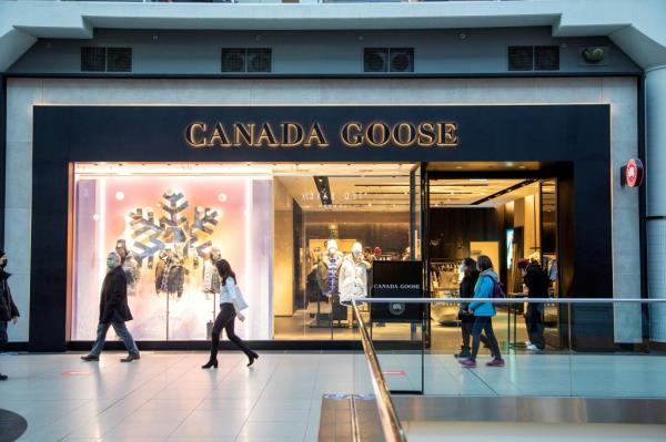 Canada Goose store in CF Toro<em></em>nto Eaton Centre shopping mall with people walking past, following announcement of corporate layoffs
