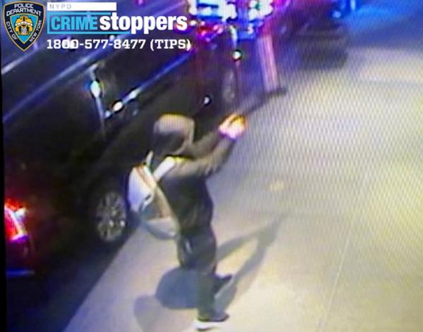 Security camera footage of Brian Thompson shooter holding up a gun