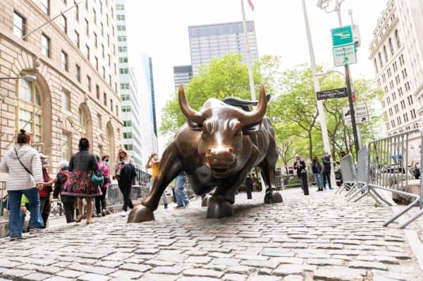 People visiting the Charging Bull statue on Wall Street after pandemic restrictions lifted in New York City