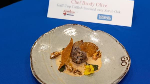 Chef Brody Olive won the 2023 Great American Seafood Cook-Off with a dish of gaff-top catfish with flash-fried mole crabs, gulf shrimp horseradish cream, pickled purslane and smoked paprika coral tuile.
