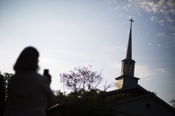Former President Jimmy Carter welcomes visitors to Maranatha Baptist Church before teaching Sunday school in Plains, Ga, Sunday, June 8, 2014. (AP Photo/John Bazemore)