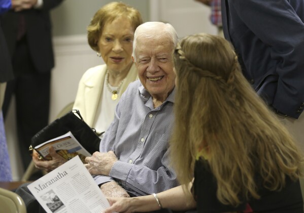 Former President Jimmy Carter talks with neighbor Stephanie Wynn before the start of bible study at Maranatha Baptist Church in Plains, Ga., on Sunday morning, Aug. 16, 2015. (Ben Gray/ The Atlanta Journal-Co<em></em>nstitution via AP)
