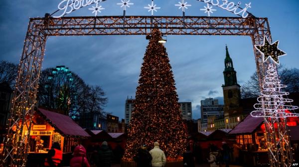 A Christmas tree greets visitors at the entrance to a traditio<em></em>nal Christmas market in Berlin, Germany, Dec. 22, 2023, as the Marienkirche church (R) is seen in the background.