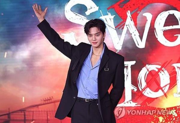 Song Kang poses for pictures at a media event for
